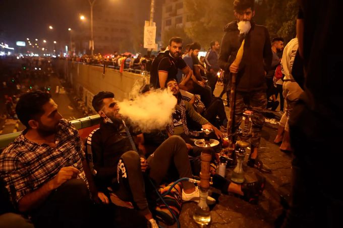 Regierungs-Gegner ruhen sich aus und rauchen eine Wasserpfeife bei den Protesten auf dem Tahrir-Platz. Proteste im Irak
