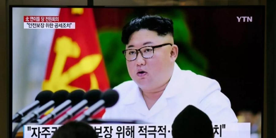 Menschen vor einem Fernsehbild von Kim Jong Un