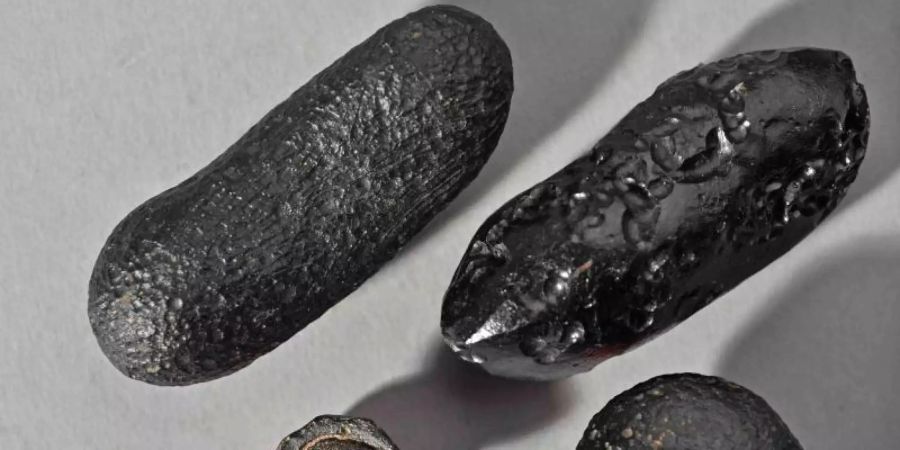 Tektite mit unterschiedlichen Formen aus Australien. Durch die Wucht des Einschlages wurden die Glaskörper tausende Kilometer weit geschleudert. Foto: -/Institut für Geowissenschaften, Universität Heidelberg/dpa