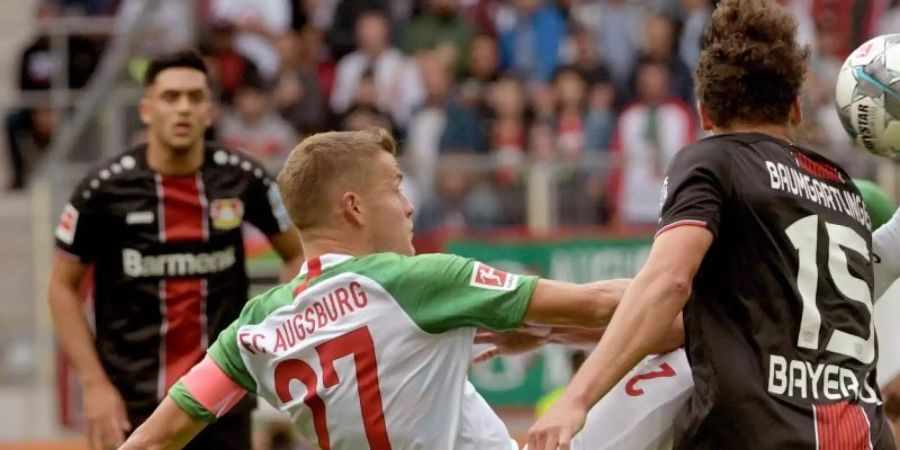 Augsburgs Alfred Finnbogason (M) macht es akrobatisch. Foto: Stefan Puchner