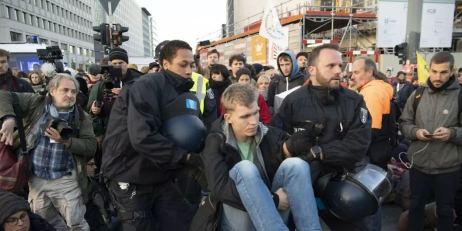 Polizisten tragen einen Demonstranten weg