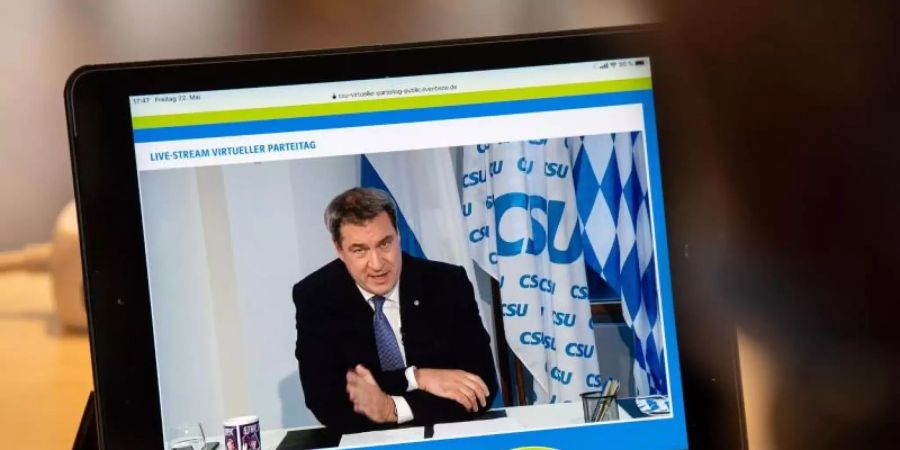 Ein Journalist beobachtet den Livestream vom CSU-Parteitag, bei dem Parteichef Markus Söder spricht. Foto: Lino Mirgeler/dpa