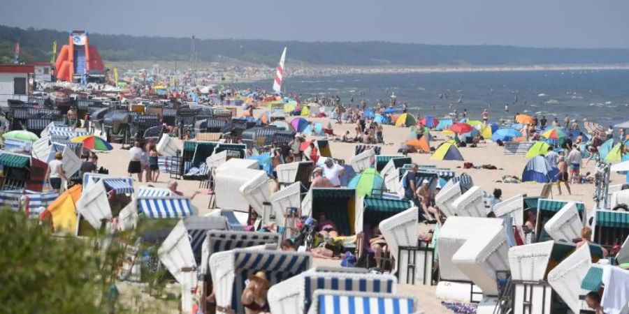 Touristen strömen bei hochsommerlichem Wetter an den Strand auf der Insel Usedom. Foto: Stefan Sauer/dpa