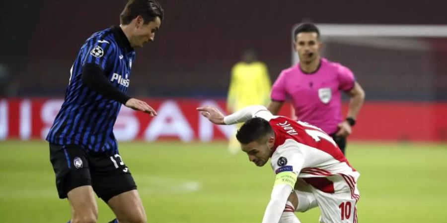 Ajax Dusan Tadic (r) gerät im Zweikampf mit Atalantas Marten de Roon ins Straucheln. Foto: Peter Dejong/AP/dpa