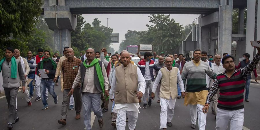 Eine Gruppe indischer Bauern protestiert auf dem Weg zum Wohnsitz des regierenden Mahesh Sharma der Bhartiya Janata Partei. Indische Bauern reichten beim Obersten Gerichtshof eine Petition ein, in der sie die Aufhebung von drei neuen Gesetzen zur Agrarreform fordern. Foto: Altaf Qadri/AP/dpa