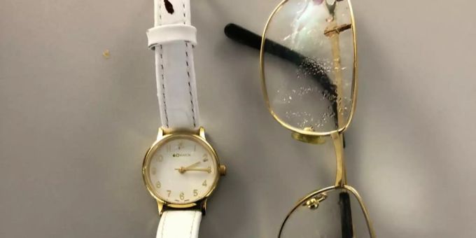 Die Frau trug diese goldfarbene Armbanduhr mit weissem Armband und diese Brille mit goldfarbenem Rahmen.