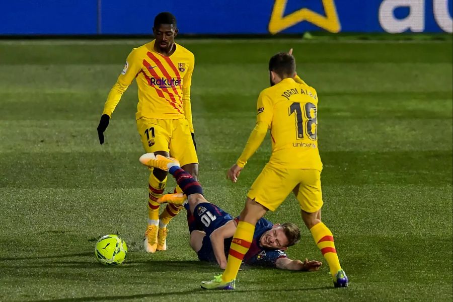 Huescas Sergio Gomez (m.) wird von Barça-Flügel Ousmane Dembélé (l.) zu Fall gebracht.