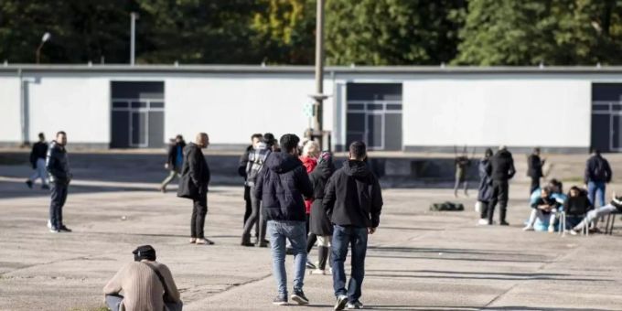 Asylsuchende laufen in der Erstaufnahmeeinrichtung Eisenhüttenstadt (D) über einen Platz. (Archivbild). Foto: Fabian Sommer/dpa deutschland