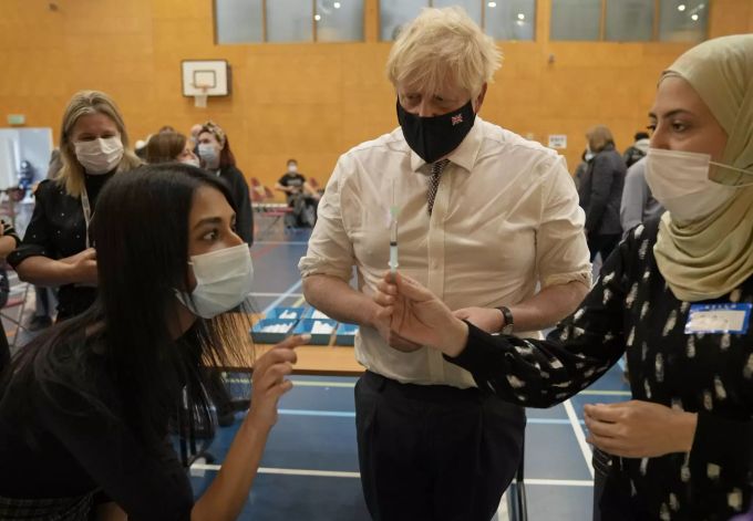 Der britische Premier Minister Boris Johnson (m.) bei einem Besuch in einem Impfzentrum in London. Coronavirus