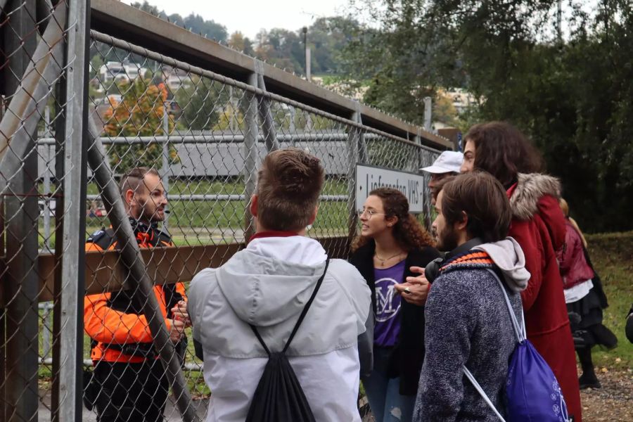 Demonstranten von Mass-Voll diskutieren mit einem Polizisten.