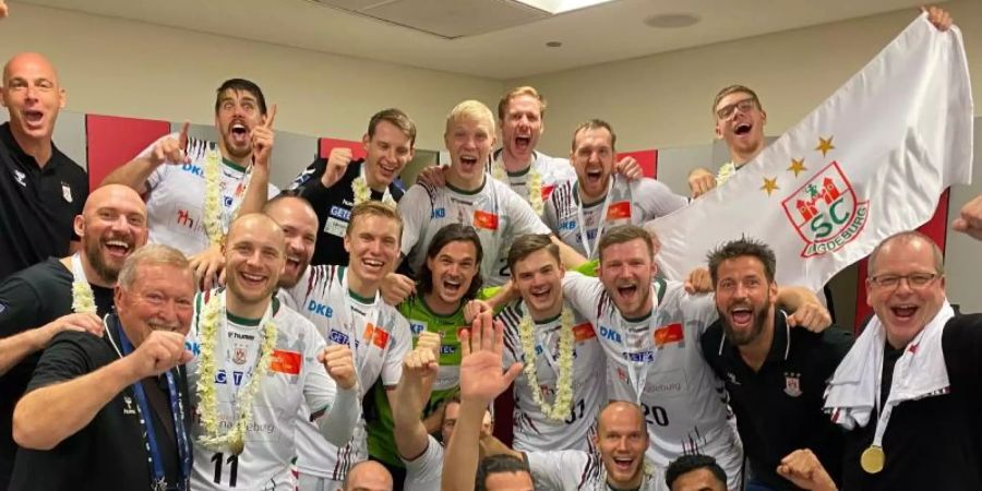Die Mannschaft des SC Magdeburg jubelt über den Sieg im Finale des IHF Super Globe in Saudi Arabien gegen den FC Barcelona. Foto: -/SC Magdeburg/dpa