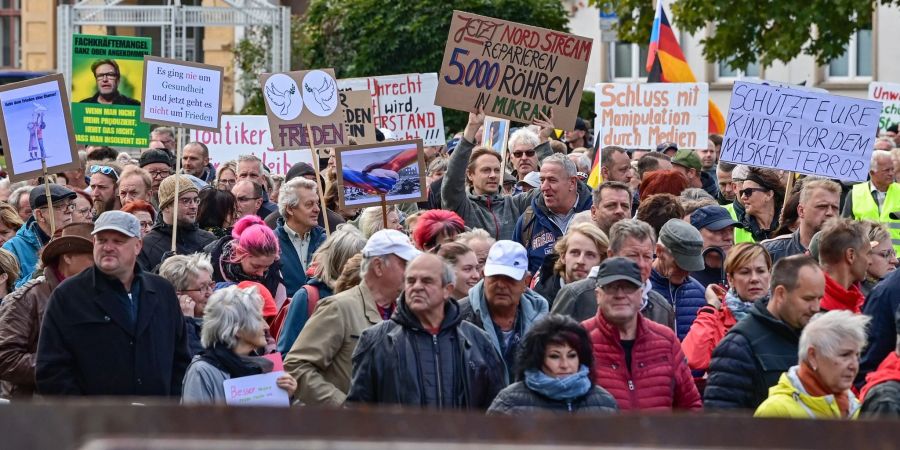 Menschen nehmen an einer Demonstration im Stadtzentrum von Frankfurt (Oder) teil - die Parolen auf den Schildern sind vielfältig.