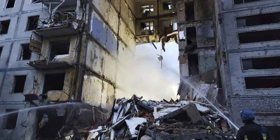 HANDOUT - Rettungskräfte arbeiten an einem durch Beschuss beschädigten Gebäude. Foto: Uncredited/Ukrainian Emergency Service/AP/dpa - ACHTUNG: Nur zur redaktionellen Verwendung im Zusammenhang mit der aktuellen Berichterstattung und nur mit vollständiger Nennung des vorstehenden Credits