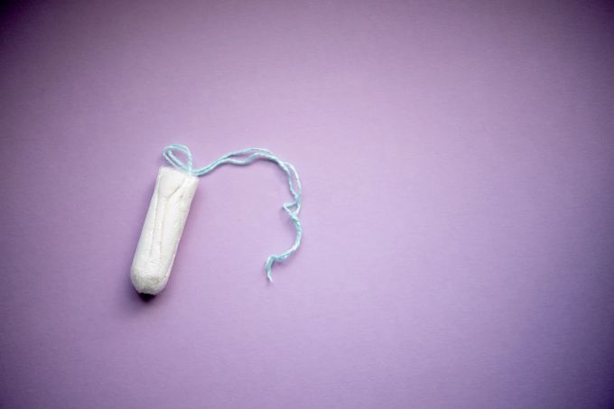 Das Ausbleiben der Menstruation – in der Medizin Amenorrhö genannt – kann auch mit dem Lebensstil zu tun haben. Tampon Frau lila weiss Hintergrund