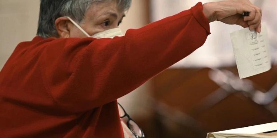 Eine Frau wirft ihren Stimmzettel in eine Wahlurne während der Parlamentswahlen in Costa Rica. Foto: Carlos Gonzalez/AP/dpa