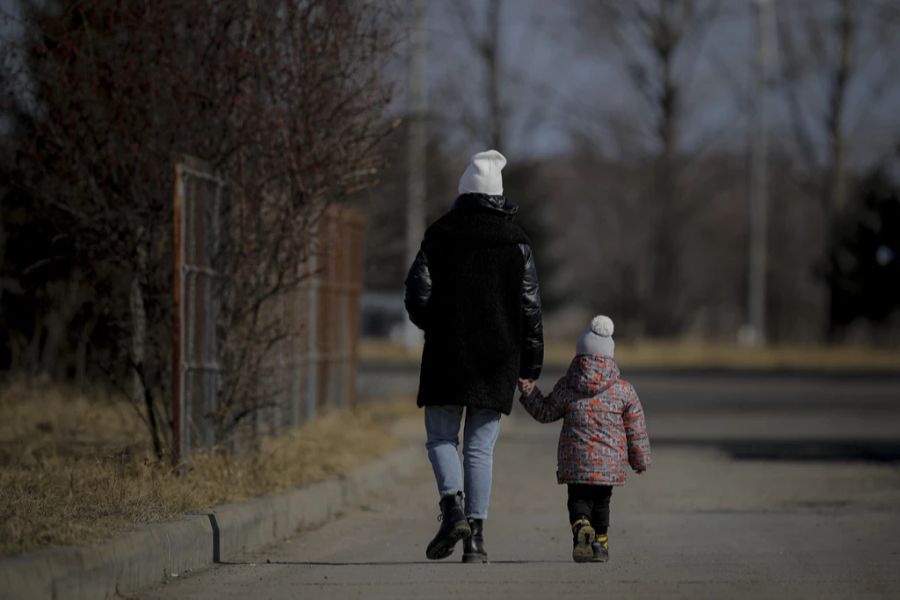 Eine Frau hält ein Kind an der Hand nach dem Überqueren der Grenze zwischen der Ukraine und Rumänien in Siret, am 25. Februar 2022.