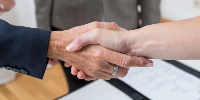 Laut einer Umfrage zeigt die Praxis: Es lohnt sich meist, das Gehalt anzusprechen. In 83 Prozent der Fälle wurde laut der Umfrage dem Wunsch nach mehr Geld entsprochen. Händedruck Folder Ring Papier