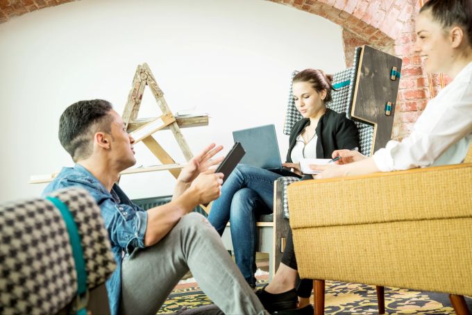 Wer zum ehemaligen Arbeitgeber zurückkehrt, sollte den Schritt auch gegenüber dem alten neuen Team erklären. Meeting Team Teppich Sessel Leiter Frauen Mann