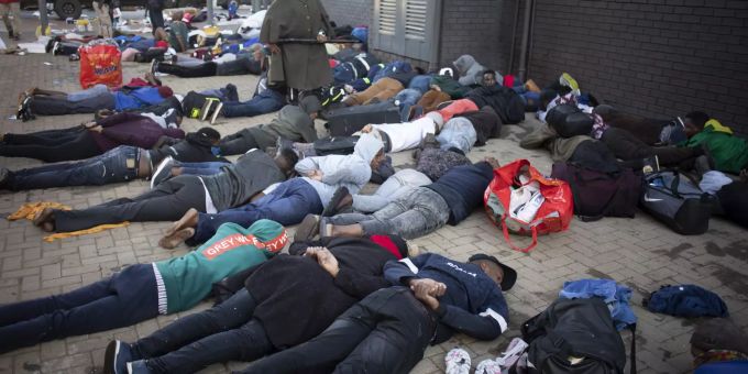 Verhaftete Menschen liegen in Johannesburg am Boden. President Zuma protests