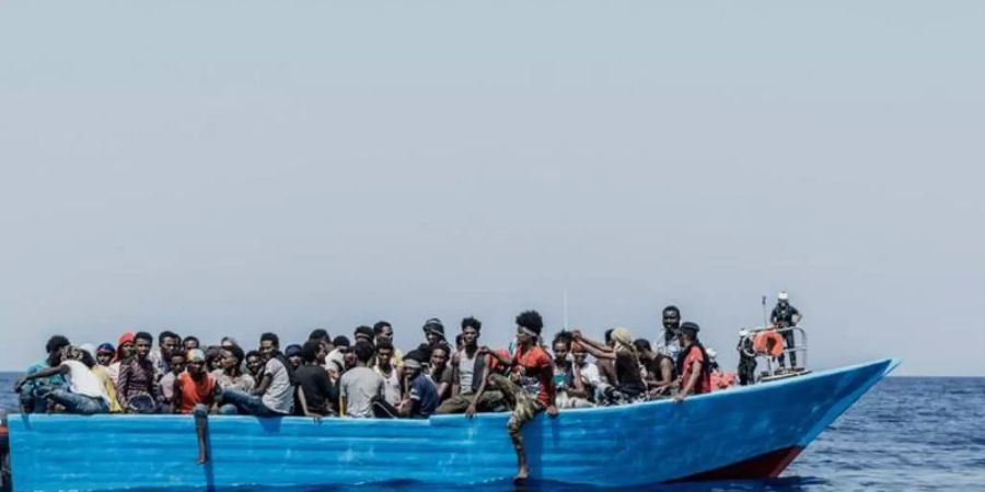 Menschen sitzen in einem Schlauchboot. Die «Ocean Viking» kam am Samstagmorgen nach eigenen Angaben mehr als 50 Menschen in der libyschen Such- und Rettungszone zu Hilfe. Foto: Flavio Gasperini/SOS Mediterranee/dpa