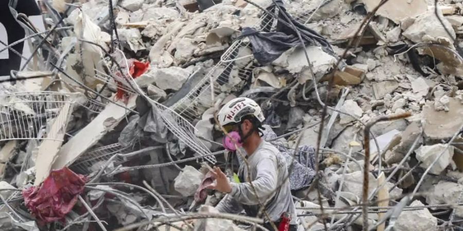 Rettungskräfte arbeiten sich durch die Trümmern des teilweise eingestürzten Wohnkomplexes. Foto: Al Diaz/Miami Herald/AP/dpa