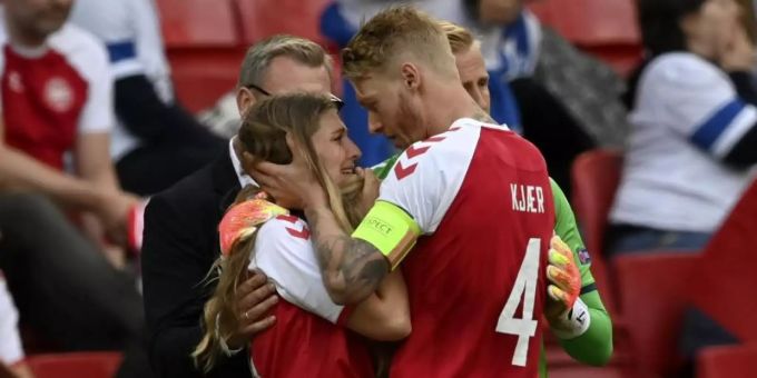 Dänemark-Kapitän Simon Kjaer (r) redet nach dem Zusammenbruch von Christian Eriksen beruhigend auf dessen Freundin ein. Foto: Stuart Franklin/Getty Pool/AP/dpa Dänemark-Kapitän Simon Kjaer (r) redet nach dem Zusammenbruch von Christian Eriksen beruhigend auf dessen Freundin ein. Foto: Stuart Franklin/Getty Pool/AP/dpa
