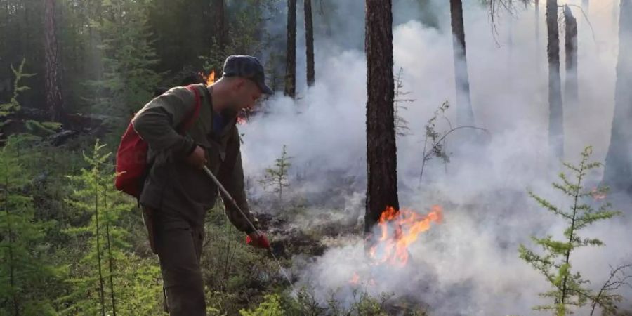 Ein Feuerwehrmann bei Löscharbeiten in der Region Jakutien. Foto: Russian Emergency Ministry Press Service/dpa