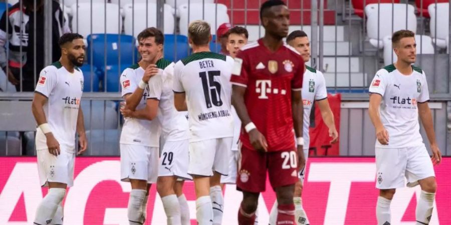 Die Gladbacher Spieler (hinten) feiern das Tor zum 1:0 gegen Bayern München. Foto: Sven Hoppe/dpa