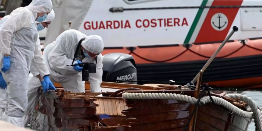 Italienische Forensiker begutachteten den Schaden an dem Boot. Foto: Gabriele Strada/AP/dpa