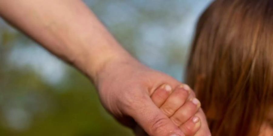 Ein junger Vater hält am Strand eines Sees die Hand seines kleinen Sohnes. Die Zahl der Neugeborenen in Europa und den USA ist wegen der Corona- Pandemie teilweise deutlich zurückgegangen. Foto: Fernando Gutierrez-Juarez/dpa-Zentralbild/dpa