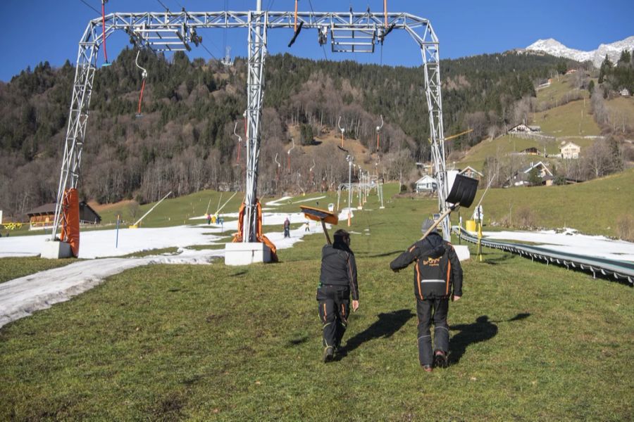 Pistenarbeiter neben der Kunstschneepiste auf der Klostermatte in grüner Landschaft, aufgenommen am Samstag, 7. Januar 2023, in Engelberg im Kanton Obwalden.