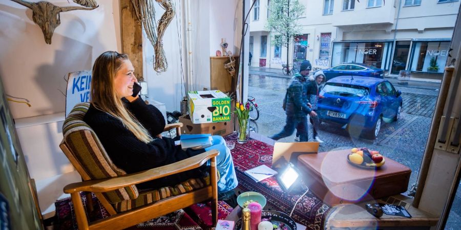 Joana V., Künstlerin, sitzt bei einer mehrtägigen Kunstperformance im Schaufenster der Galerie Heba im Atelier Hermann Solowe im Kreuzberger Wrangelkiez.