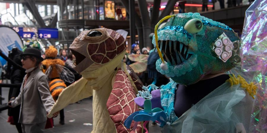Klima-Aktivisten der Gruppe Extinction Rebellion tragen bei einem Tanz-Flashmob im Berliner Hauptbahnhof fantasievolle Tierkostüme.