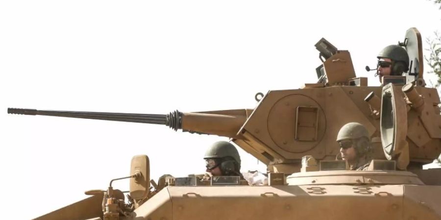 Soldaten der türkischen Streitkräfte sitzen in einem Panzer nahe der Grenze zwischen Syrien und der Türkei. Foto: Anas Alkharboutli/dpa/Archiv