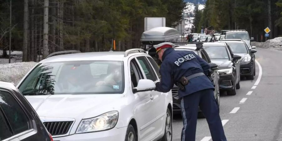 Polizisten kontrollieren Personen in St. Anton am Arlberg in den Tiroler Alpen. Foto: Expa/Erich Spiess/APA/dpa
