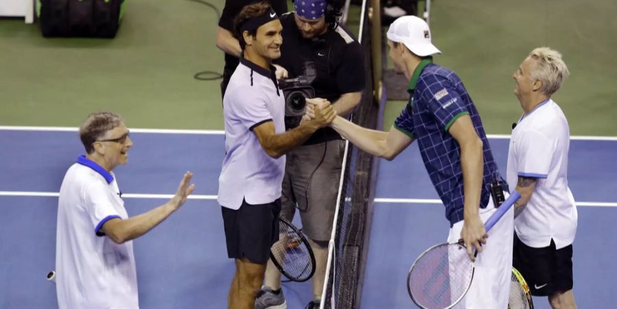 Roger Federer schüttelt John Isner die Hand. Der Schweizer spielte beim Math for Africa mit Bill Gates (links) Doppel. Partner von Isner war Mike McCready, Gitarrist von Pearl Jam.