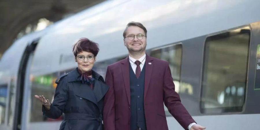 Zwei Mitarbeiter präsentieren die neue Dienstkleidung der Deutschen Bahn. Foto: Boris Roessler/dpa
