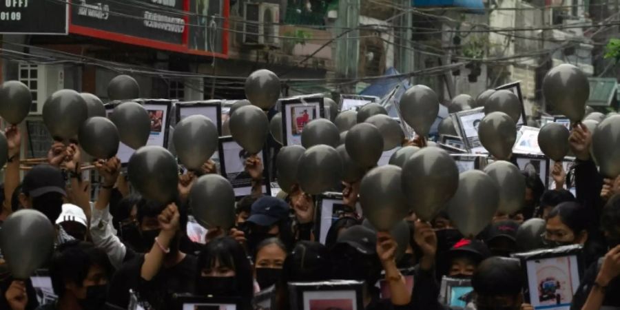 Demonstranten mit Bildern Getöteter in Yangon
