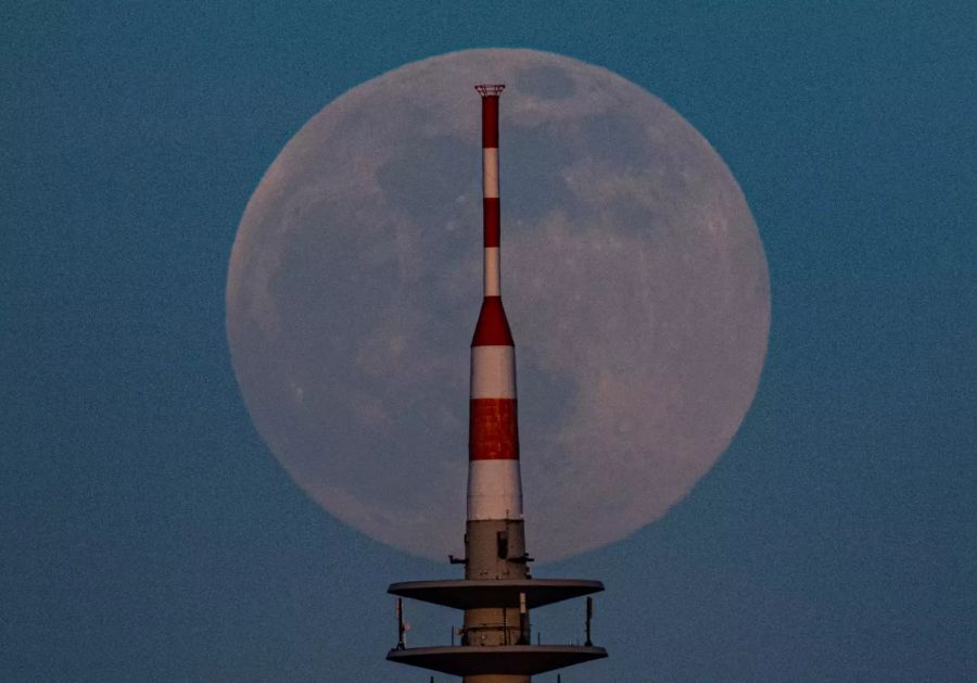 Der Mond geht hinter der Fernsehturm von Frankfurt am Main auf.