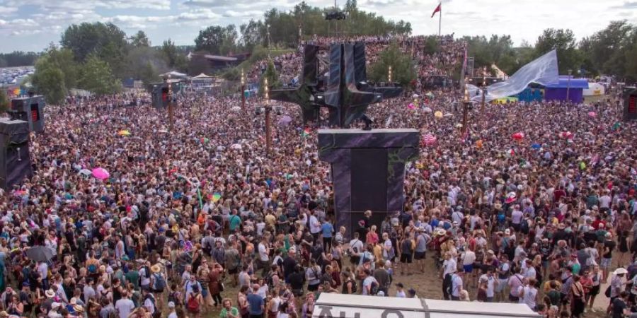 Besucher tanzen vor der Hauptbühne des vom Verein Kulturkosmos organisierten Fusion-Festivals 2019. Foto: Jens Büttner/dpa-Zentralbild/dpa