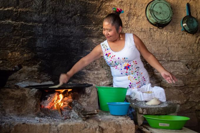 Eine mexikanische Frau bereitet Tortillas zu. Frau brät Tortillas