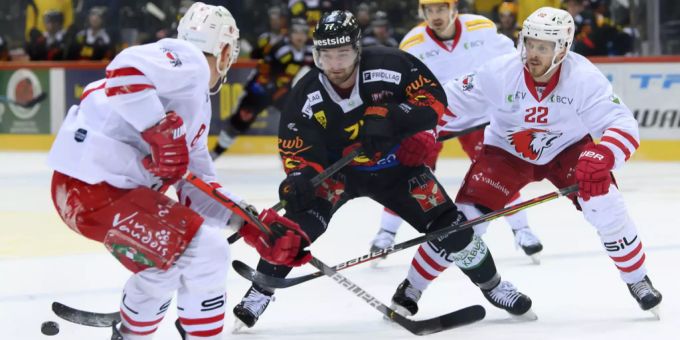 Ronald Kenins (links), Yanik Burren (SCB) und Lausannes Christoph Bertschy kämpfen um den Puck. SCB Lausanne