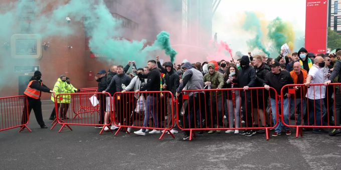 Fans verschieben Absperrungen vor dem Stadion und zünden Rauchfackeln bei einem Protest. Vor dem Premier-League-Spiel haben Hunderte United-Fans den Platz im Stadion gestürmt, um gegen die US-amerikanischen Inhaber des Clubs zu protestieren. Manchester United FC Liverpool