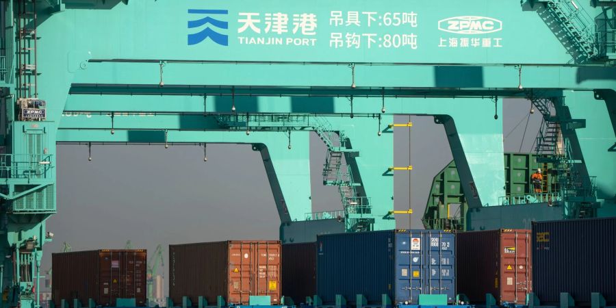 Unbemannte Lastwagen bewegen Schiffscontainer in einem automatisierten Containerhafen in Tianjin.