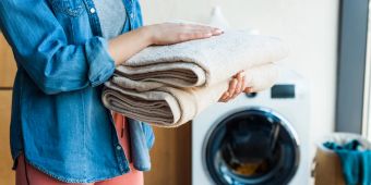 frauenhände halten gefaltete handtücher, wäscheraum