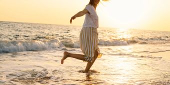 Frau tanzt am Strand