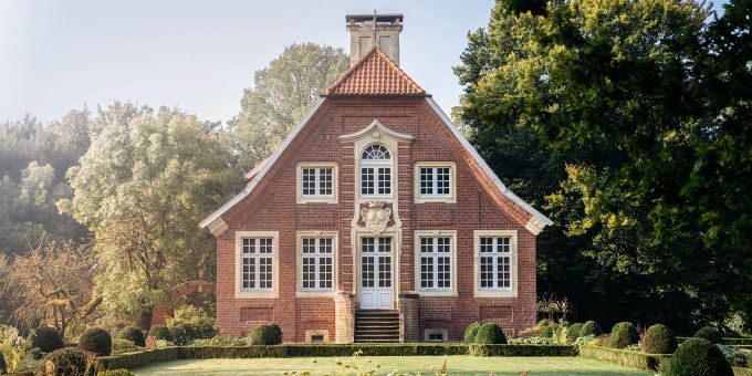 Der Lyrik führt entlang der wichtigsten Lebensstätten von Droste-Hülshoff, darunter das Haus Rüschhaus. Haus Backstein rot Garten