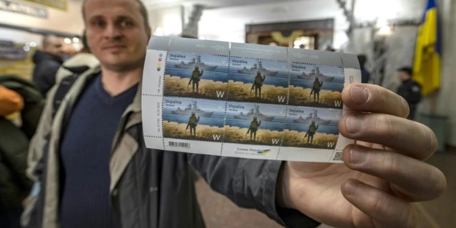 Mann hält Briefmarken