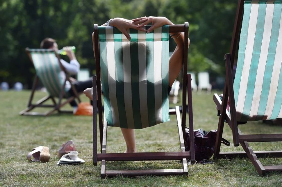 Menschen sonnen sich im Green Park in London.