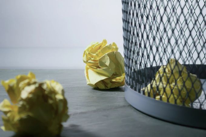 Werden eigene Vorschläge immer wieder ausgebremst, kann das im Job zu grosser Unzufriedenheit führen. Mülleimer Papierkorb Papier geknüllt Boden